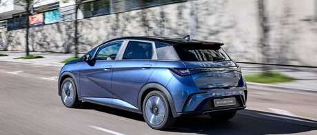 Billede af en blå BYD Dolphin som kører på vejen