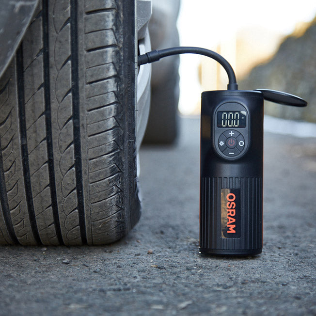 Osram TYREinflate 2000 mini-kompressor på asfalten tilsluttet et bildæk