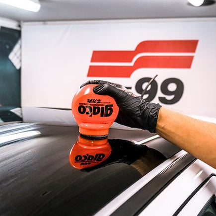 Hånd med Glaco Roll-on Max rudecoating på bilrude for ultra hydrofobisk effekt
