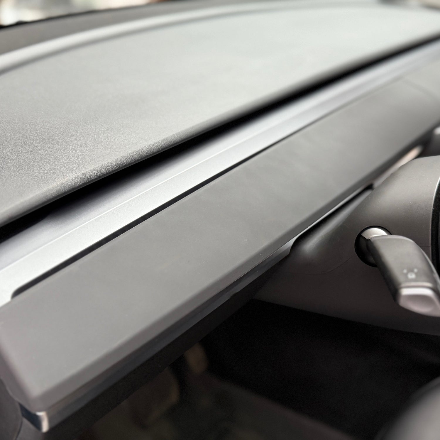 Sort dashboard cover til Tesla Model 3/Y, tæt på bilens interiør.