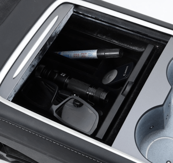 Opbevaringsboks til Tesla Model 3/Y fyldt med forskellige genstande.