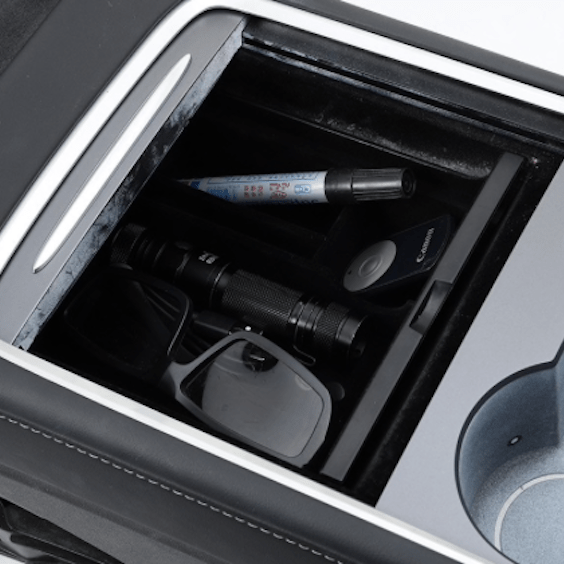 Opbevaringsboks til Tesla Model 3/Y fyldt med forskellige genstande.