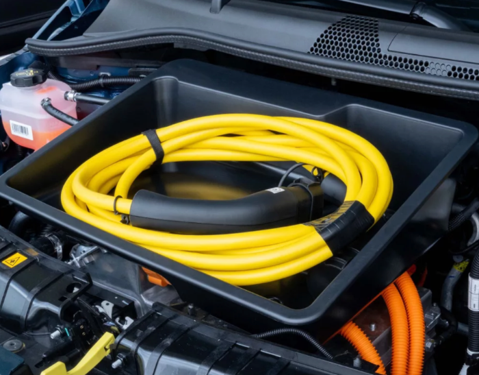 Frunk opbevaringsboks med oprullet ladekabel i frontbagagerummet på en bil.