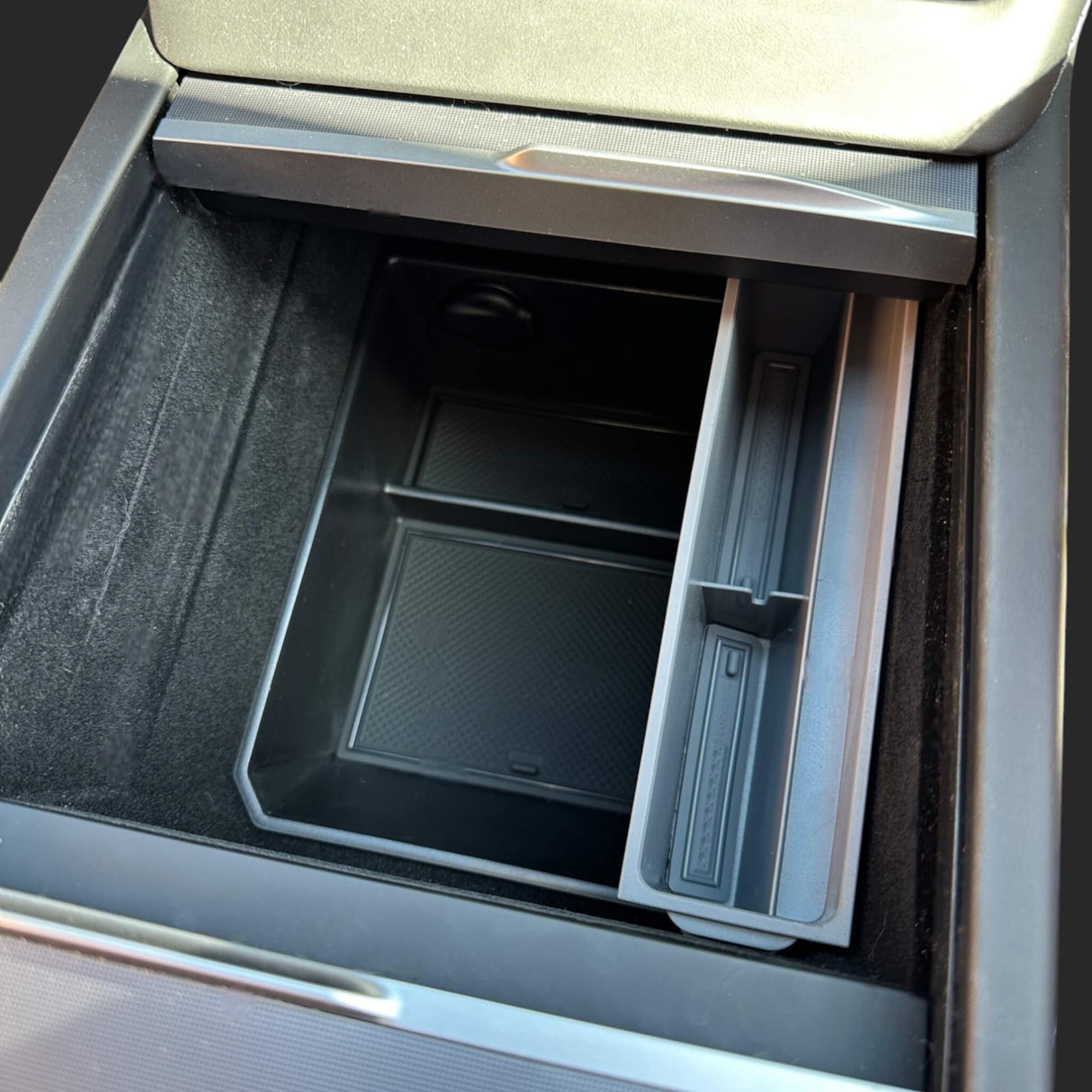 Solbrilleholder i bilens midterkonsol, designet til at passe Tesla-modeller.