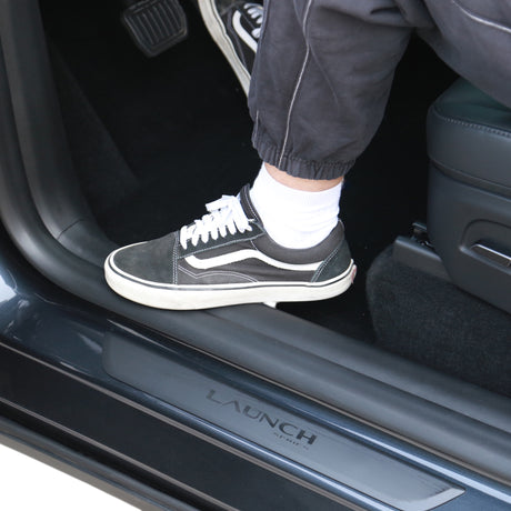 Beskyttelseslister til Tesla Model Y 2025, monteret og vist med fod på.