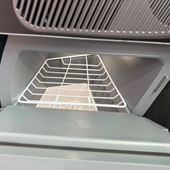 Køleskab til Tesla Model Y med åben låge og integreret hylde vist indefra.