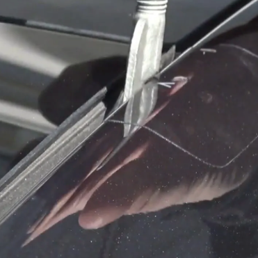 Folie beskytter imens der bliver monteret kroge til tagbøjler på en tesla