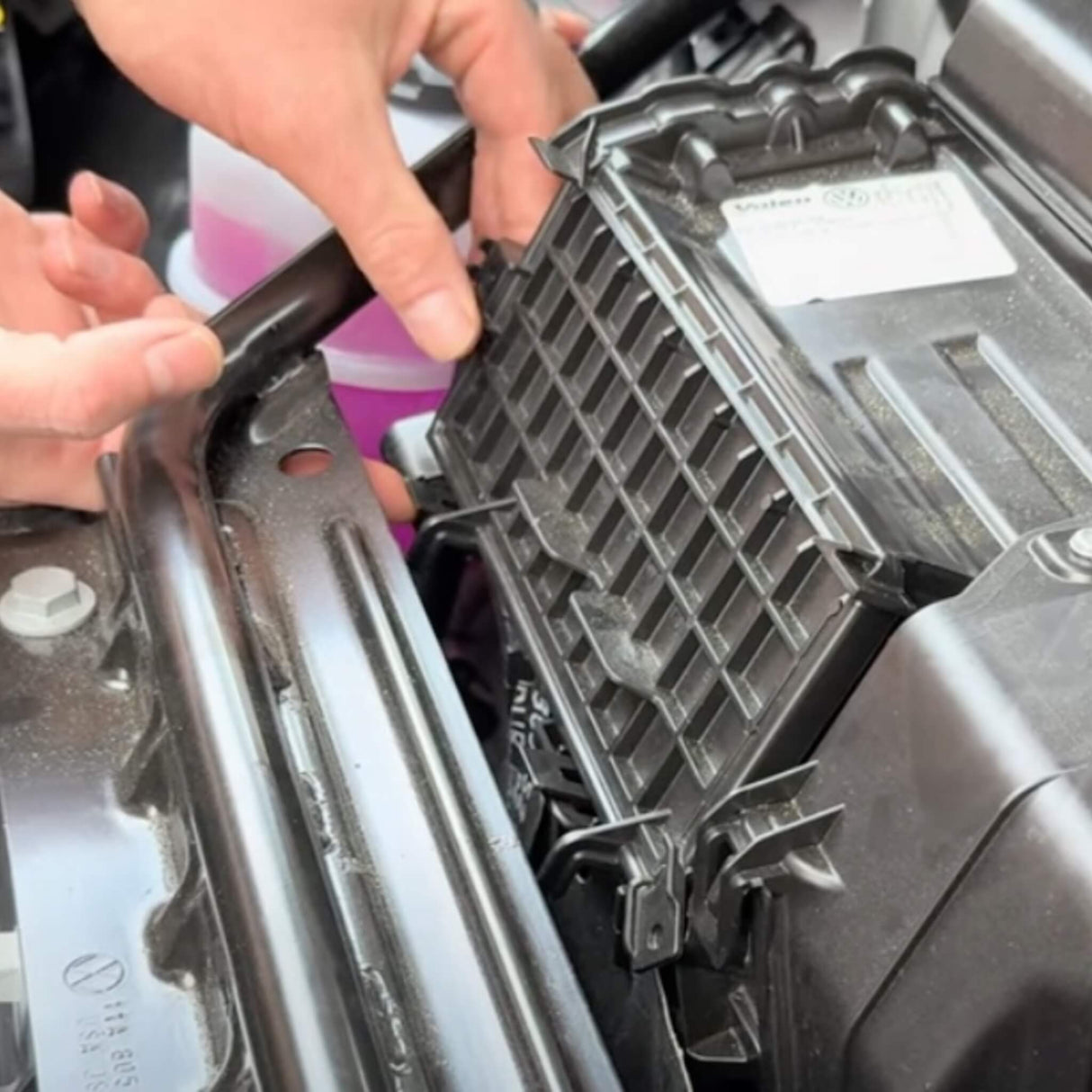 Person installerer et kul luftfilter i motorrummet på en VW ID.3/4/5/6/7.