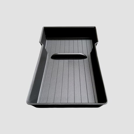 Sort opbevaringsbakke til armlæn, designet til Tesla Model Y Juniper, vist på grå baggrund.