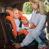 Mor spænder barn fast i Recaro Xenon 1 Kid autostol i bilen, begge smiler