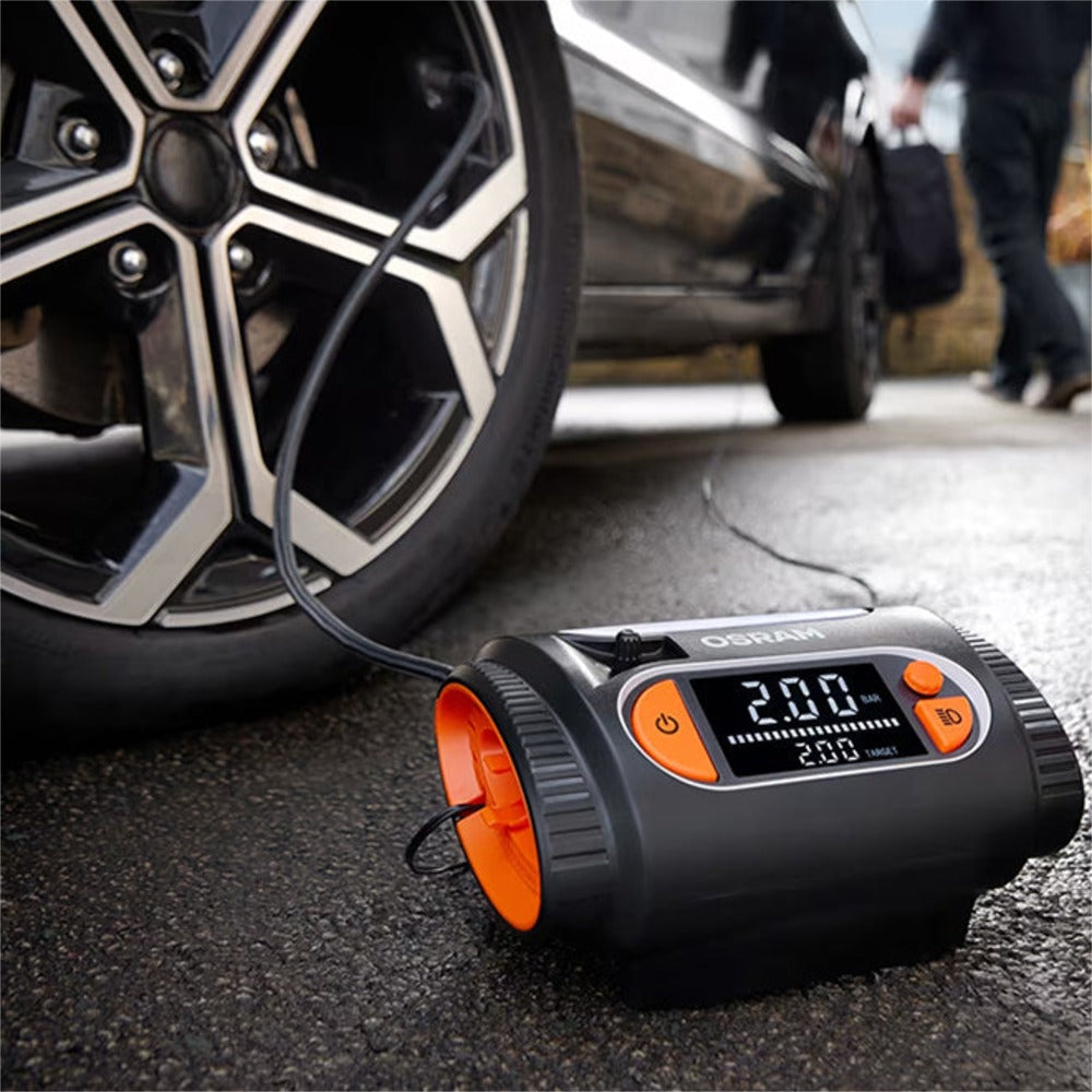 Osram TYREinflate 2130 kompressor på gaden med personer og bil i baggrunden