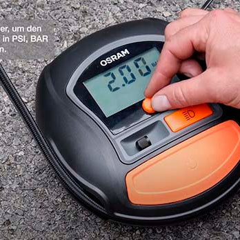 Hånd indstiller dæktrykket på displayet af Osram TYREinflate 450 mini-kompressor
