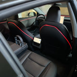 Rødt ambientelys langs plastikryglænet på forsæderne i en Tesla Model 3 Highland