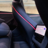 Rødt ambientelys langs plastikryglænet på forsæderne i en Tesla Model 3 Highland, set fra siden