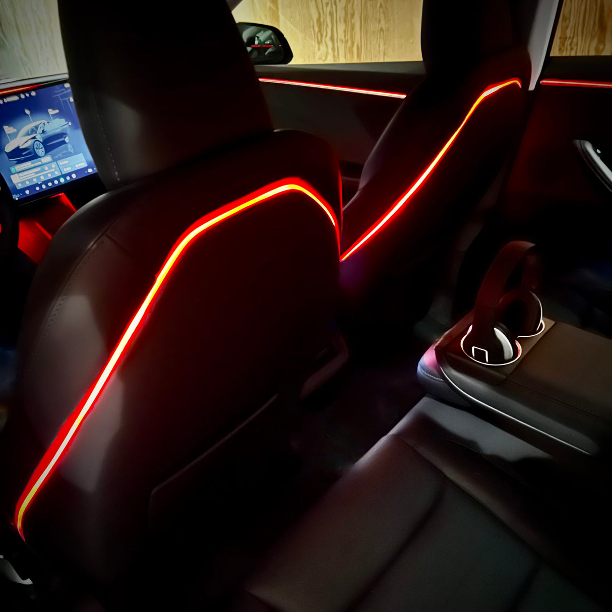 Rødt ambientelys langs plastikryglænet på forsæderne i en Tesla Model 3 Highland