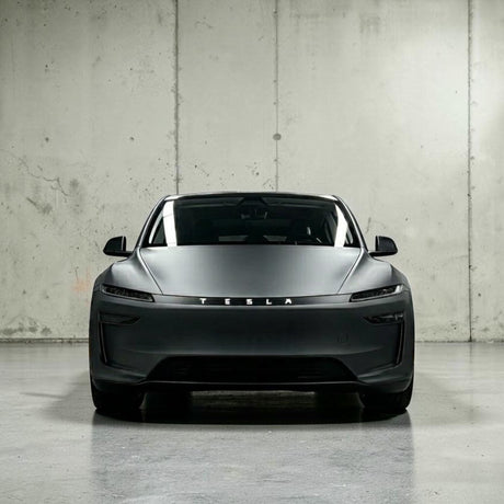 Tesla Model Y 2025 Juniper set forfra i mat grå, viser TESLA logo på lystribe