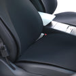 Sort sædeovertræk monteret på forsædet i en Tesla Model 3 eller Model Y, set tæt på.