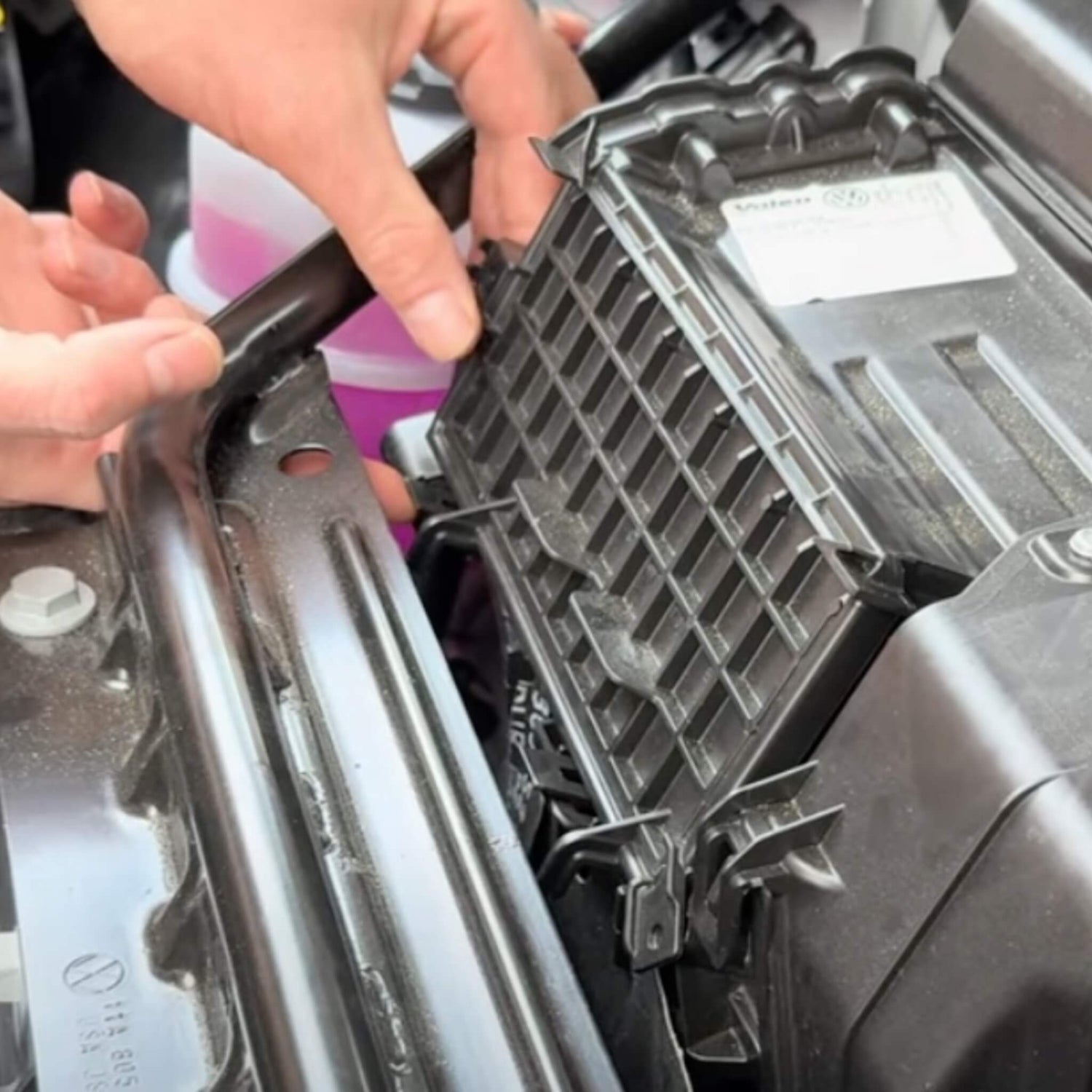 Person installerer et kul luftfilter i motorrummet på en VW ID.3/4/5/6/7.