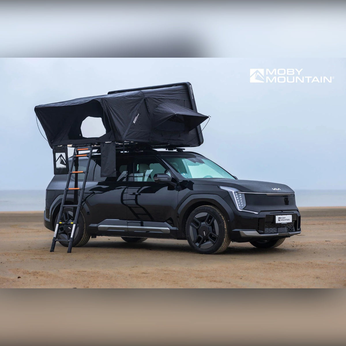Moby Mountain Peak XXL tagtelt i thunderBlack med teleskopstige på Kia EV9 set fra siden