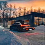 Thule Arcos XL bagageboks 450L monteret på anhængertrækket på en sort elbil i sne ved solnedgang