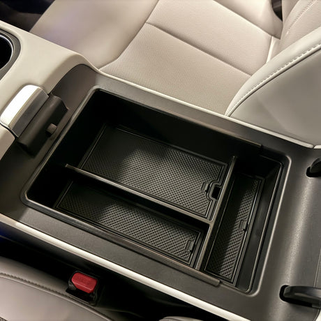 Placeret opbevaringsboks til xpeng G6 ved armlænet i farven sort. 